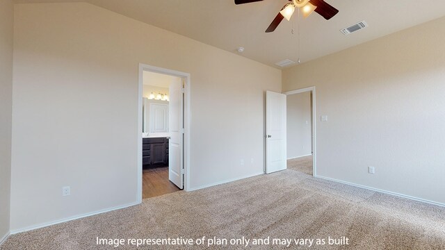 unfurnished bedroom with ceiling fan, ensuite bath, vaulted ceiling, and light colored carpet