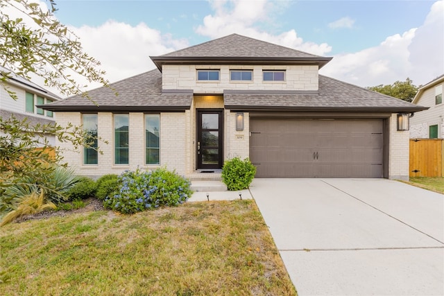 view of front of home with a front yard and a garage