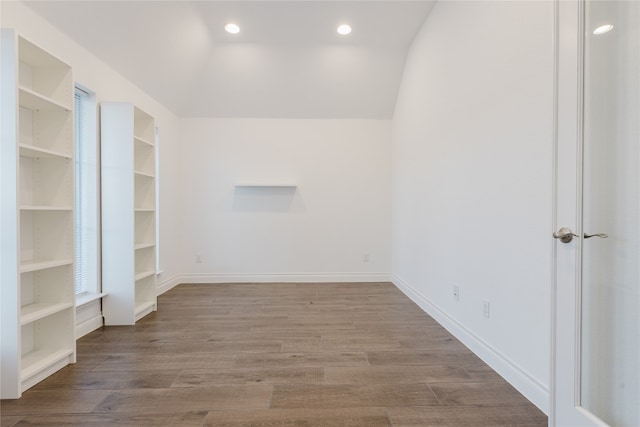 spare room with hardwood / wood-style flooring and lofted ceiling