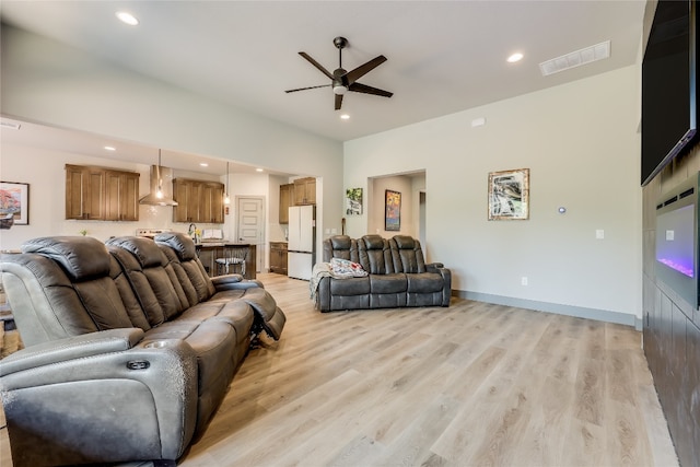 living room with ceiling fan and light hardwood / wood-style flooring