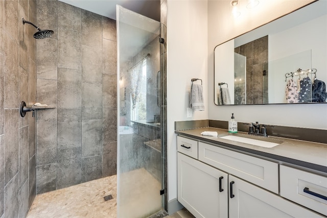 bathroom featuring tiled shower and vanity