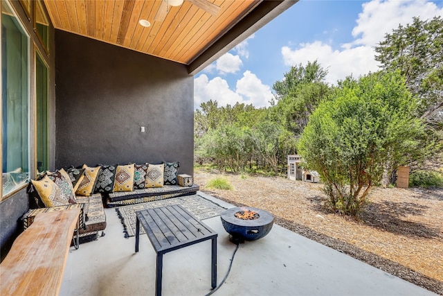 view of patio with ceiling fan and an outdoor living space with a fire pit