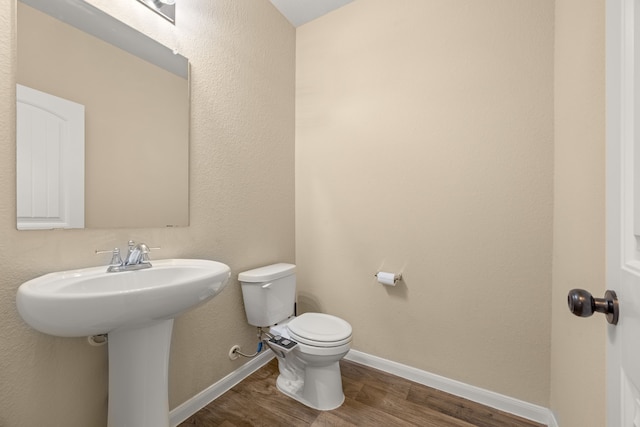 bathroom featuring sink, hardwood / wood-style floors, and toilet