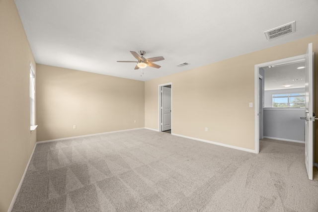 empty room featuring ceiling fan and light colored carpet