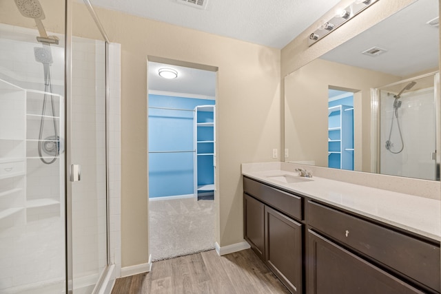 bathroom featuring vanity, a shower with shower door, and hardwood / wood-style flooring