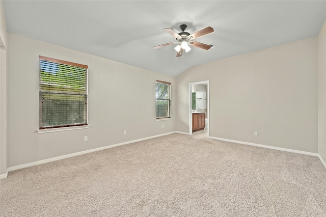 empty room with ceiling fan, light colored carpet, and lofted ceiling