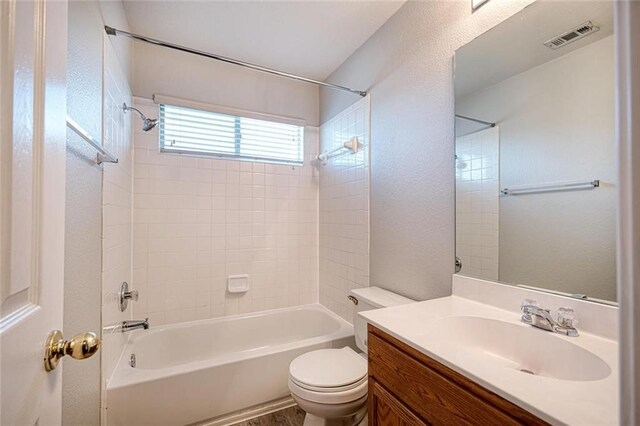 full bathroom with vanity, toilet, and tiled shower / bath