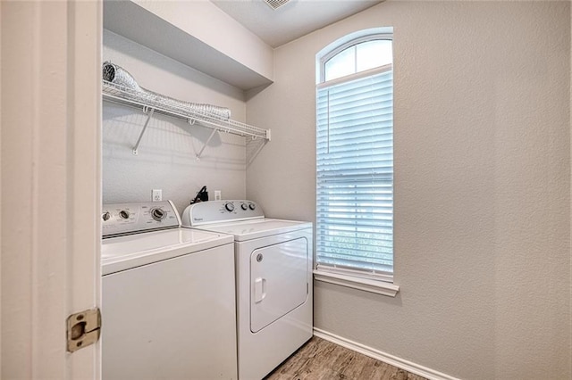 laundry area with washing machine and clothes dryer and wood-type flooring