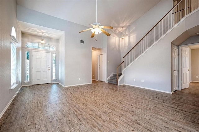 foyer featuring hardwood / wood-style floors, ceiling fan, and a high ceiling