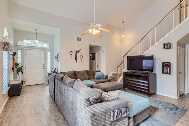 living room with wood-type flooring, high vaulted ceiling, and ceiling fan