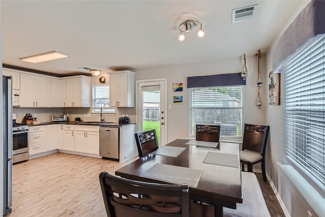 dining room with light hardwood / wood-style floors and sink