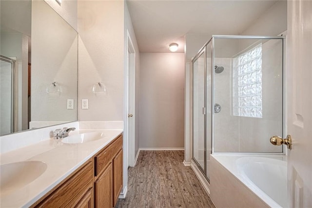 bathroom with vanity, wood-type flooring, and shower with separate bathtub