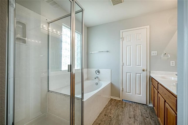 bathroom with wood-type flooring, vanity, and separate shower and tub