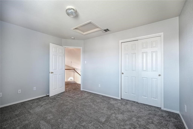 unfurnished bedroom with dark carpet and a closet