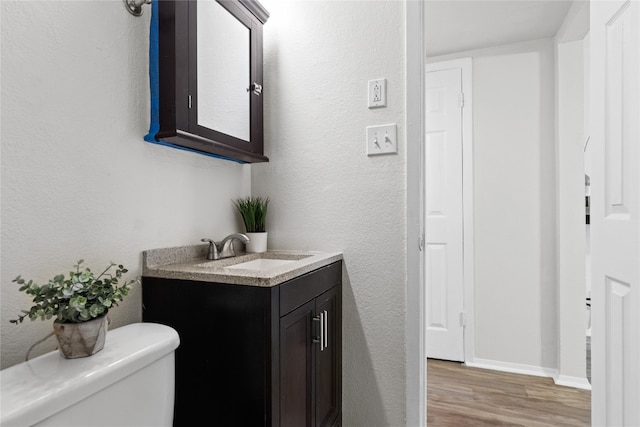 bathroom featuring hardwood / wood-style floors, vanity, and toilet