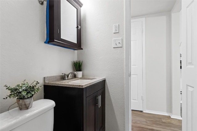 bathroom featuring hardwood / wood-style flooring, vanity, and toilet