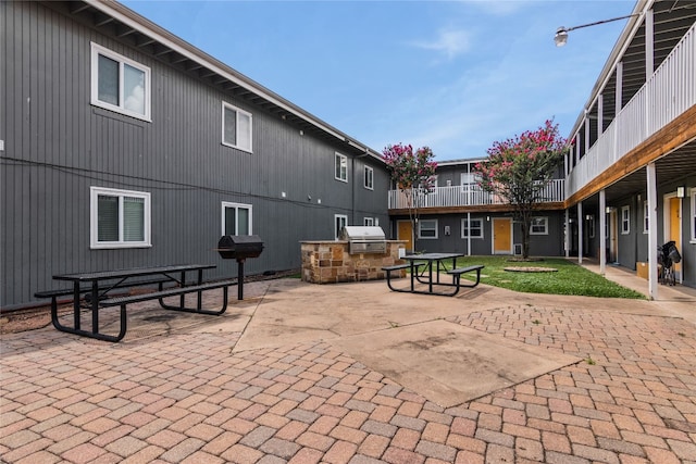 view of property's community featuring a lawn, area for grilling, and a patio area