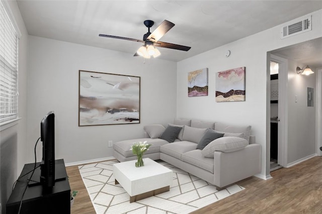 living room with ceiling fan and light hardwood / wood-style flooring