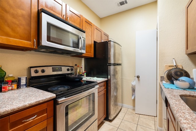 kitchen featuring appliances with stainless steel finishes and light tile flooring