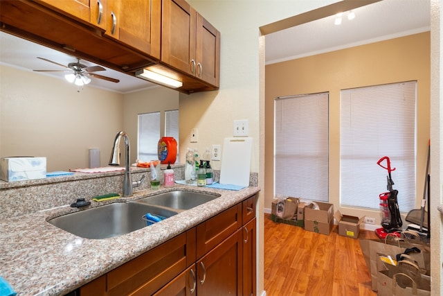 kitchen featuring ceiling fan, light hardwood / wood-style floors, sink, and ornamental molding