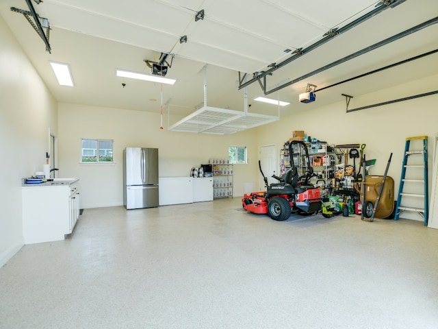 garage with stainless steel fridge and a garage door opener