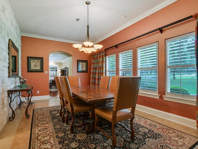 tiled dining room with ornamental molding and an inviting chandelier