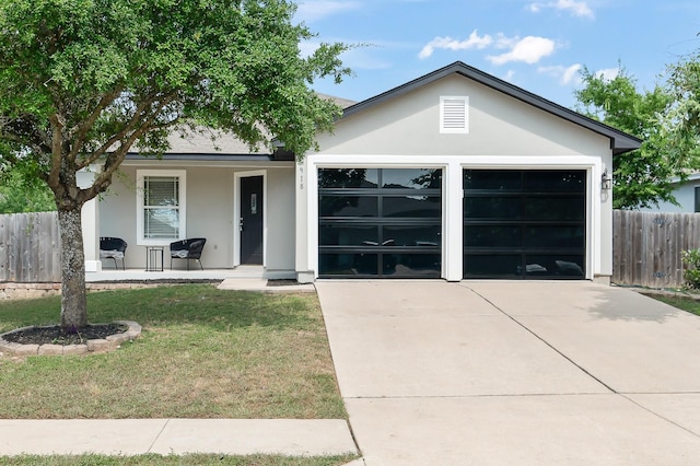 view of front facade featuring a garage, a front yard, and a porch