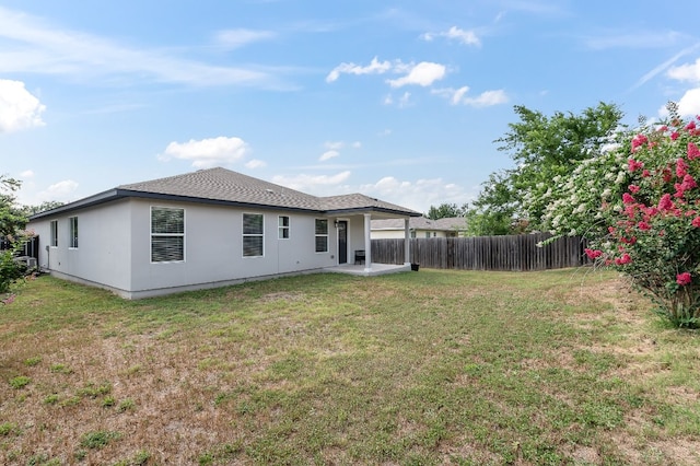 back of house featuring a patio area and a lawn