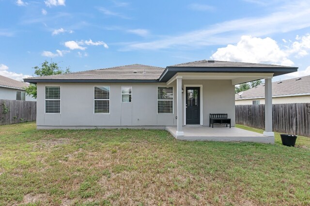 back of property featuring a yard and a patio