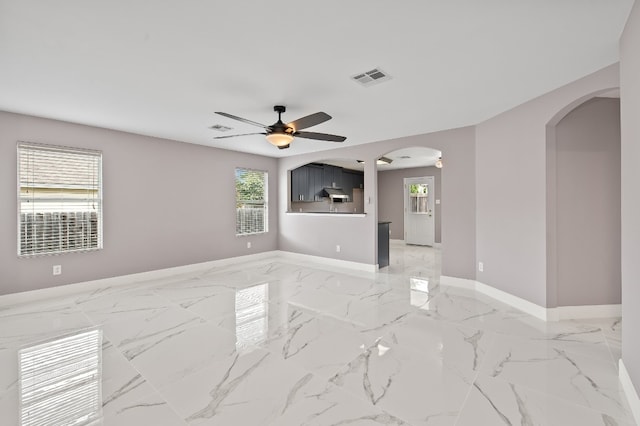 unfurnished room featuring ceiling fan and a healthy amount of sunlight