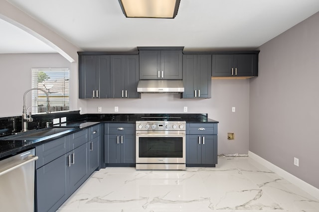 kitchen with stainless steel appliances, dark stone countertops, and sink