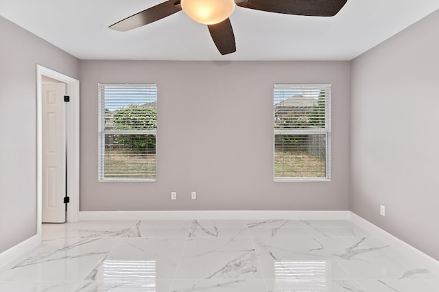 empty room featuring ceiling fan and a wealth of natural light