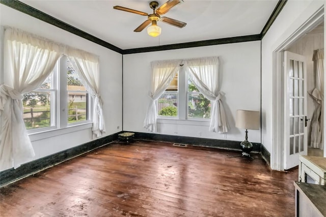 spare room featuring ceiling fan, hardwood / wood-style floors, a healthy amount of sunlight, and ornamental molding