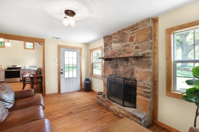 living room with light hardwood / wood-style floors and a fireplace