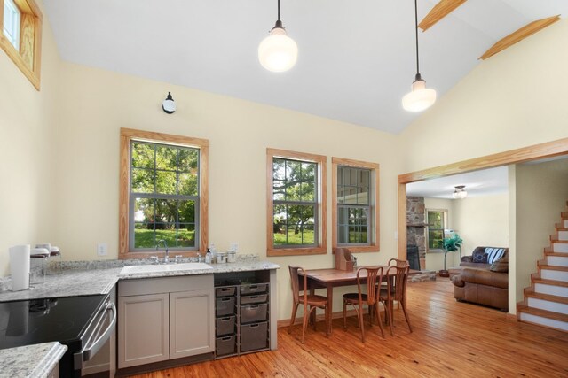 kitchen featuring light hardwood / wood-style floors, gray cabinets, sink, and hanging light fixtures