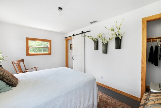 bedroom with a barn door, a closet, and a spacious closet