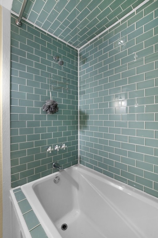 bathroom featuring tiled shower / bath