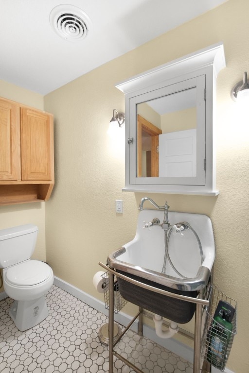 bathroom featuring tile flooring and toilet