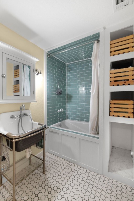 bathroom with tile floors and shower / bath combo with shower curtain