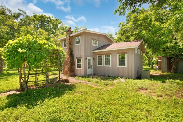 rear view of house featuring an outdoor structure