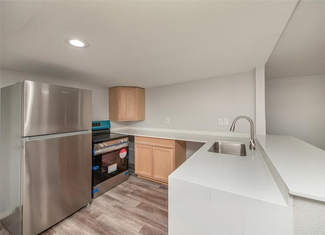 kitchen with sink, light brown cabinets, kitchen peninsula, appliances with stainless steel finishes, and light wood-type flooring