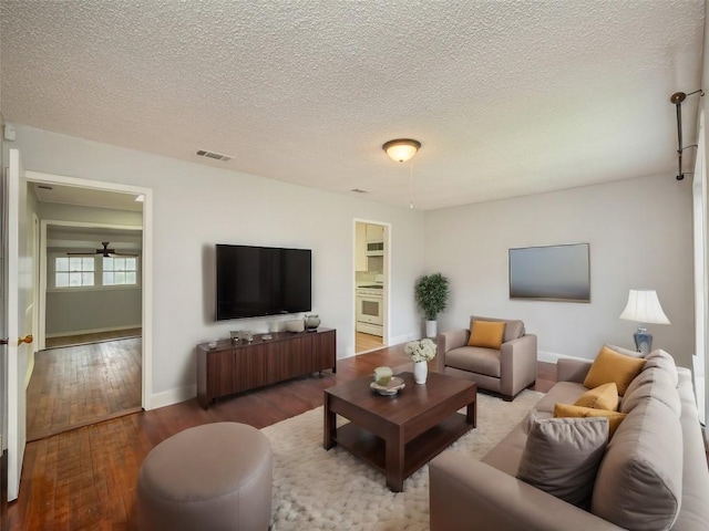 living room with ceiling fan, wood-type flooring, and a textured ceiling