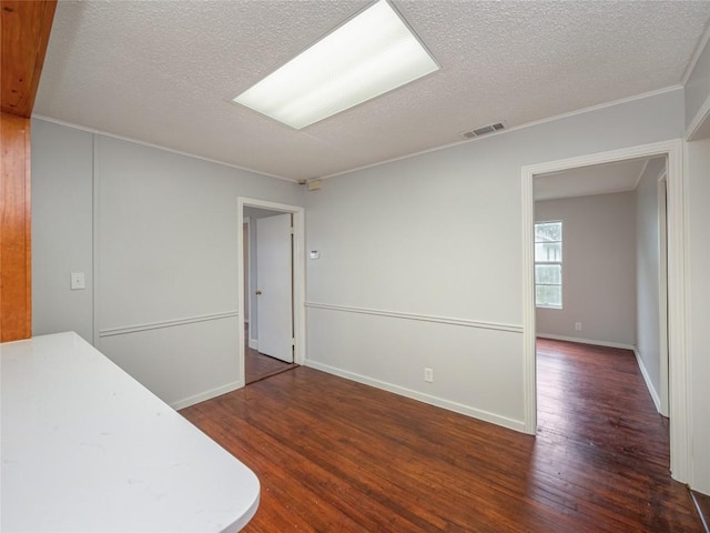 interior space featuring dark hardwood / wood-style flooring, a textured ceiling, and ornamental molding