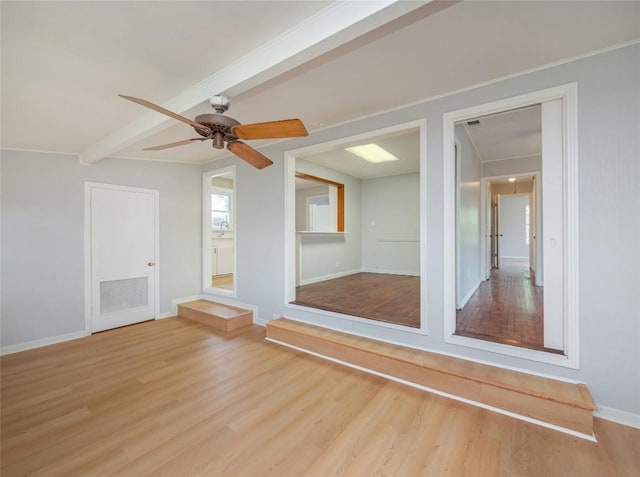 empty room featuring ceiling fan, sink, beamed ceiling, and light hardwood / wood-style floors