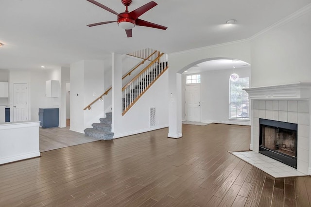 3917 Canyon Glen Cir, Austin, TX 78732 - unfurnished living room featuring wood-type flooring, ceiling fan, ornamental molding, and a tiled fireplace