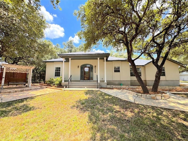 rear view of property featuring a lawn and covered porch