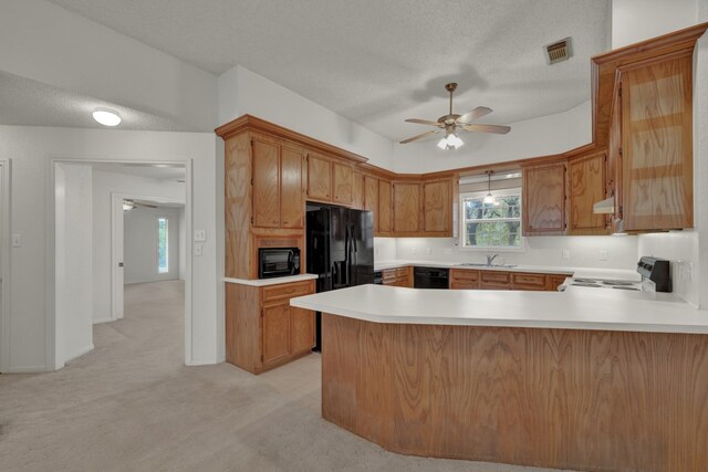 kitchen featuring ceiling fan, kitchen peninsula, a textured ceiling, light carpet, and black appliances