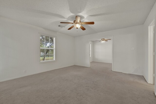 carpeted empty room featuring a textured ceiling