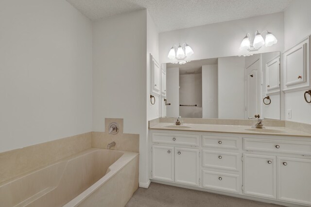 bathroom with vanity, a textured ceiling, and a bathing tub