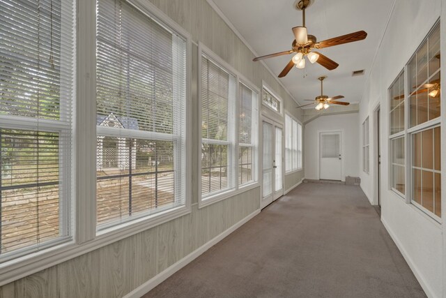 unfurnished sunroom with ceiling fan